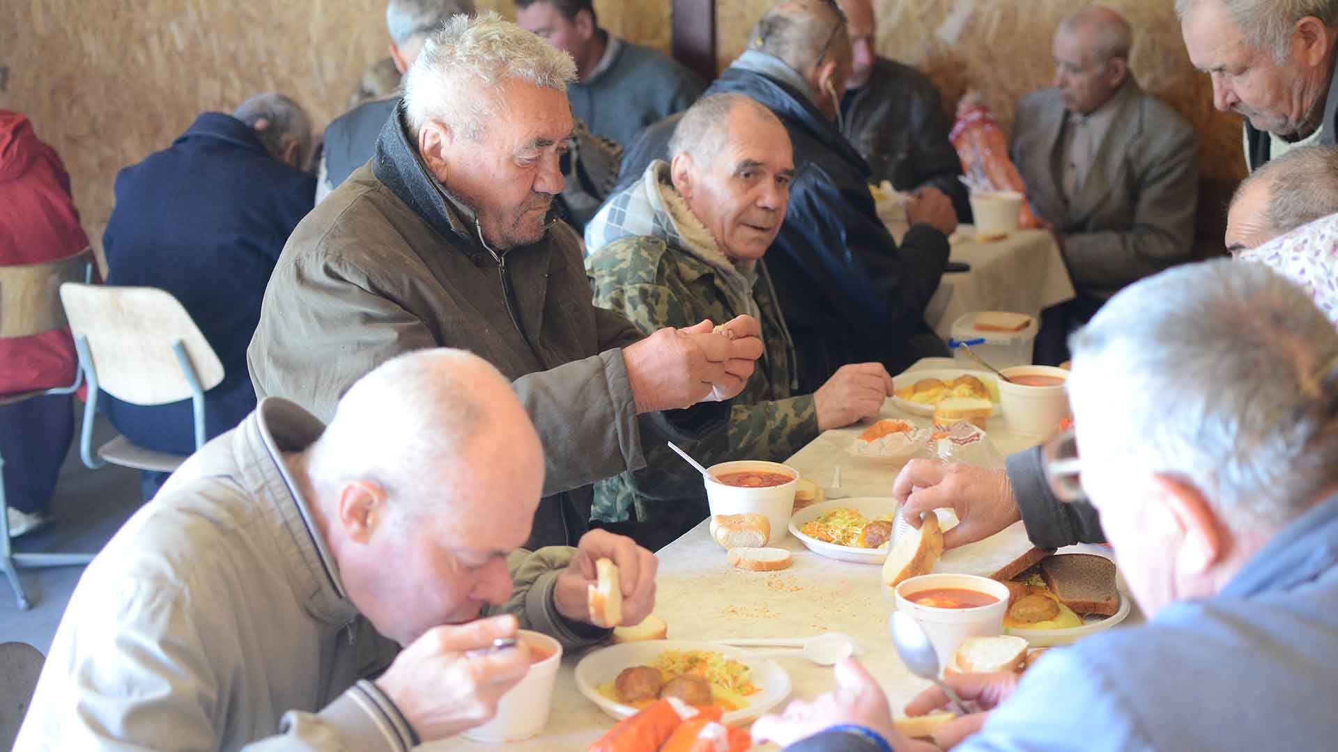People eating warm soup and bread.
